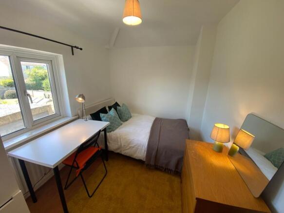 This inviting double bedroom features a cozy at...