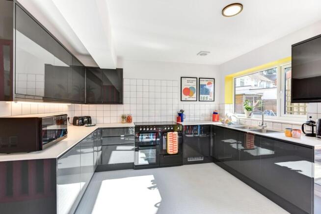A modern, spacious kitchen featuring sleek blac...