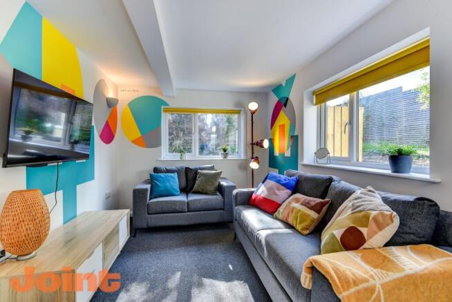 This vibrant living room features a cozy seatin...