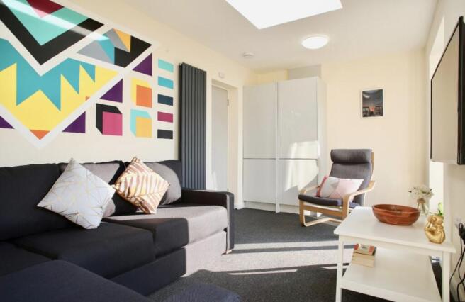 This vibrant living room features a cozy seatin...