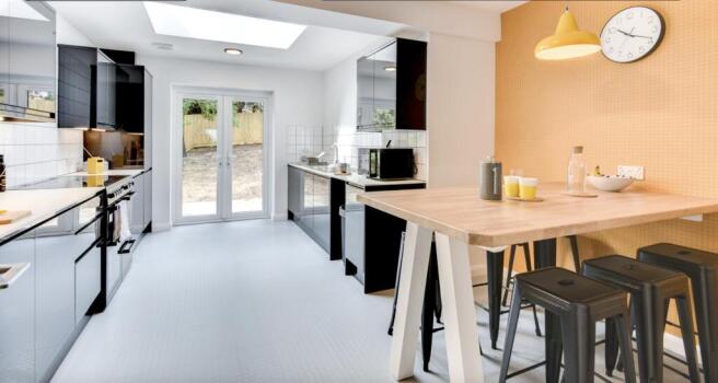 This modern kitchen features sleek black cabine...