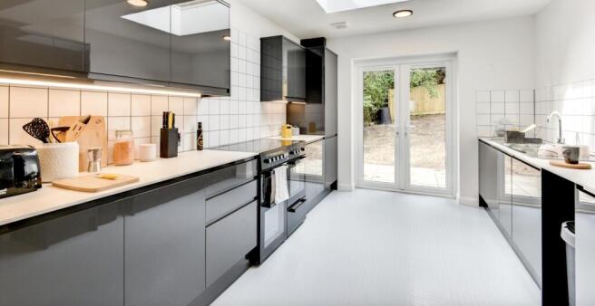 This modern kitchen features sleek cabinetry, a...