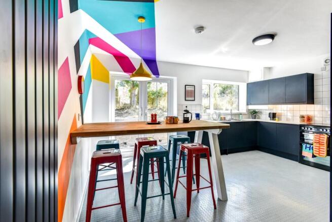 A vibrant and modern kitchen featuring colorful...