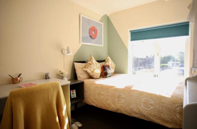 This charming double bedroom features a cozy be...