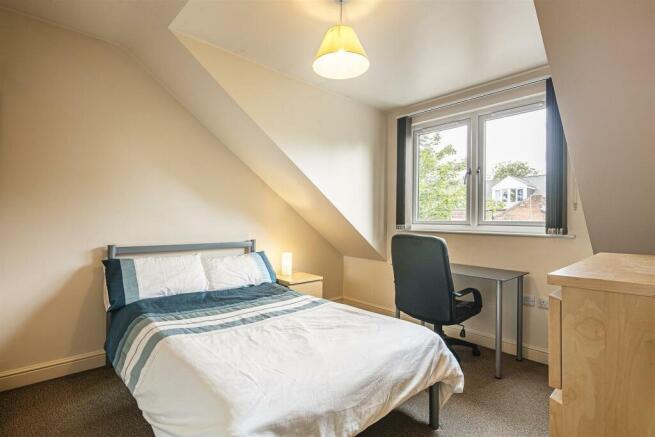 This cozy double bedroom features a comfortable...