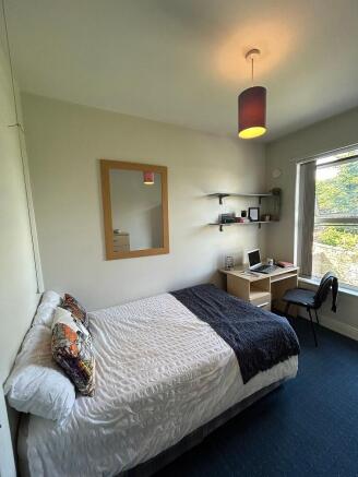 Cozy double bedroom featuring a comfortable bed...