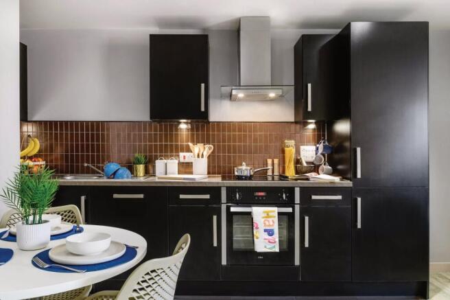 This modern kitchen features sleek black cabine...