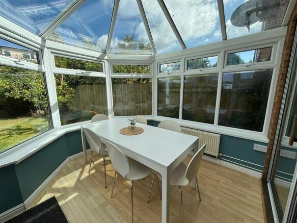 A bright and inviting garden room featuring a s...
