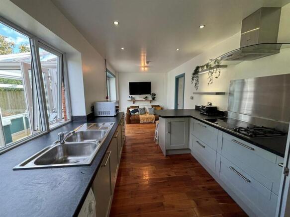 This modern kitchen features sleek countertops ...