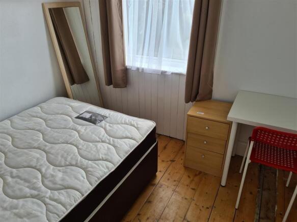 This cozy double bedroom features a comfortable...