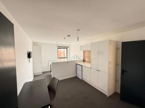 Modern kitchen area featuring sleek cabinetry a...