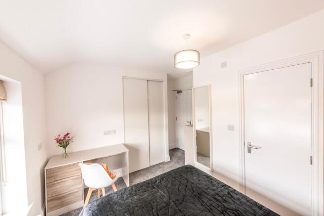 This inviting double bedroom features a comfort...