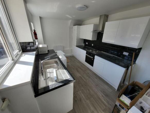 This modern kitchen features sleek white cabine...