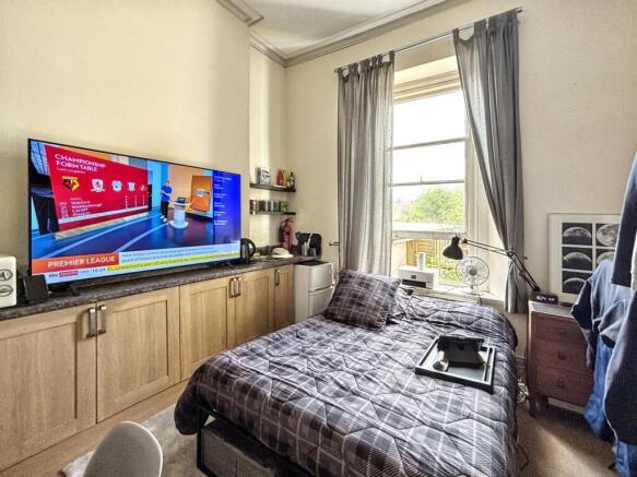 This cozy double bedroom features a comfortable...