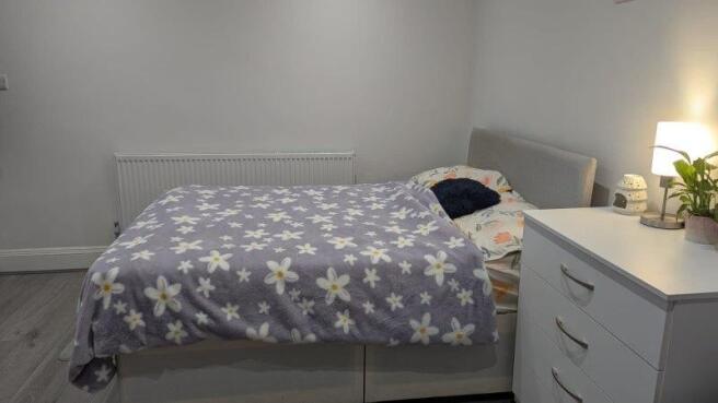 This cozy double bedroom features a comfortable...