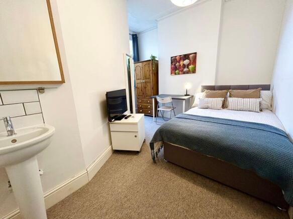 A charming double bedroom featuring a cozy bed,...