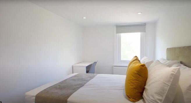A bright and inviting double bedroom featuring ...