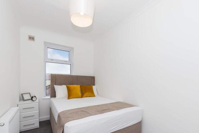This cozy double bedroom features a comfortable...
