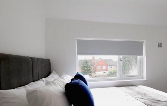 This inviting double bedroom features a comfort...