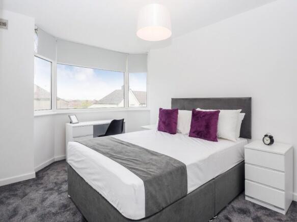 This stylish double bedroom features large wind...