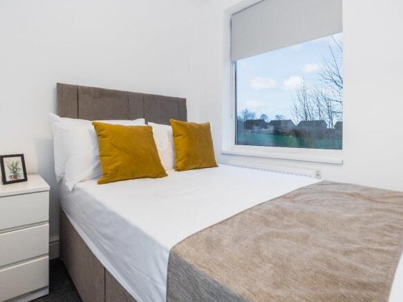 This inviting double bedroom features a comfort...