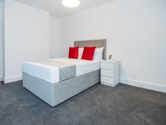 This cozy double bedroom features a comfortable...