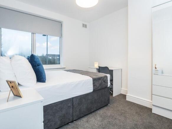 This stylish double bedroom features a generous...