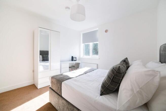 This contemporary double bedroom features a coz...