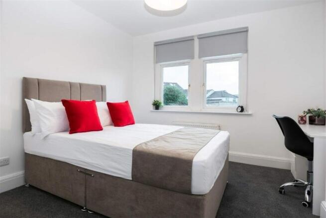 This inviting double bedroom features a comfort...