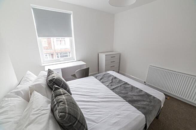 This inviting double bedroom features a comfort...