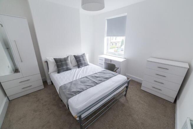 This inviting double bedroom features a comfort...