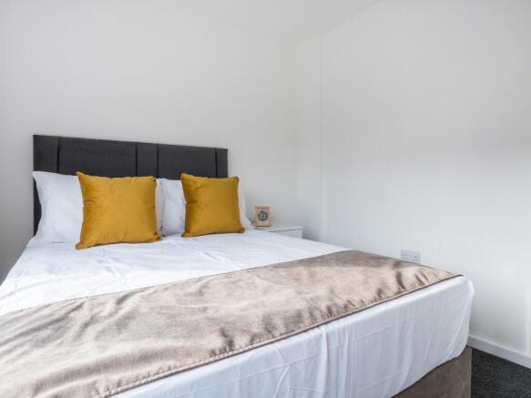 This inviting double bedroom features a comfort...