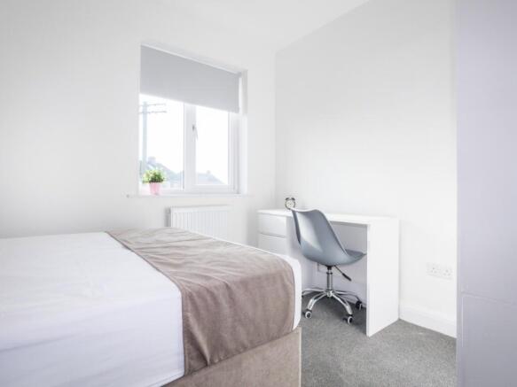 This inviting double bedroom features a cozy at...