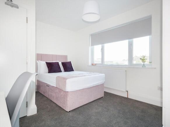 A bright and inviting double bedroom featuring ...