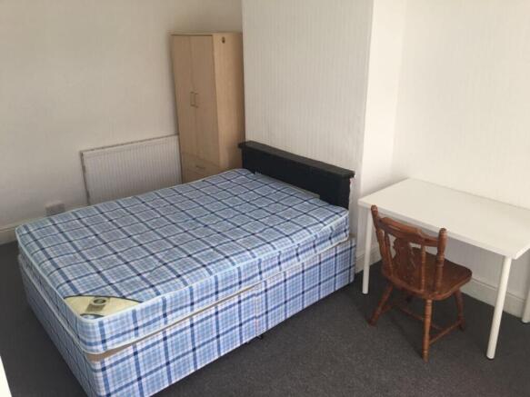 This inviting double bedroom features a comfort...
