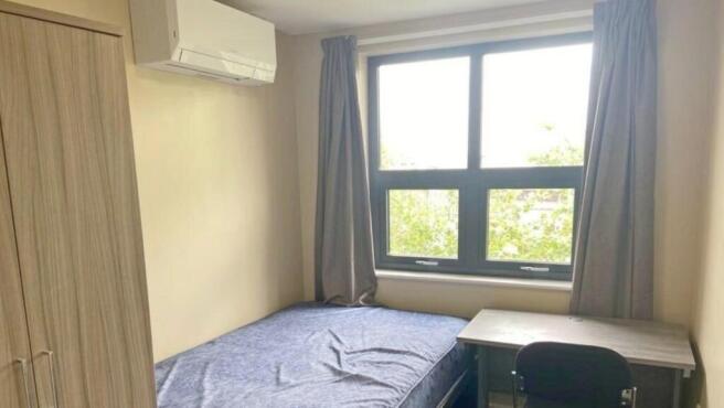 A bright and tidy double bedroom featuring a co...