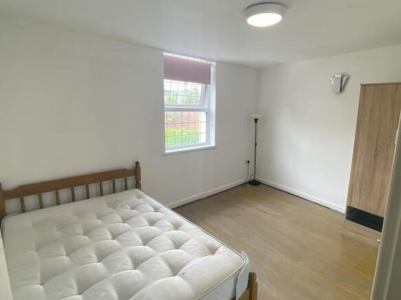 A bright double bedroom featuring a comfortable...
