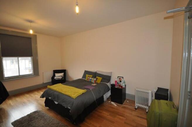 A spacious and bright double bedroom featuring ...