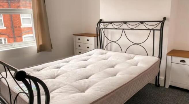 A bright double bedroom featuring a stylish met...