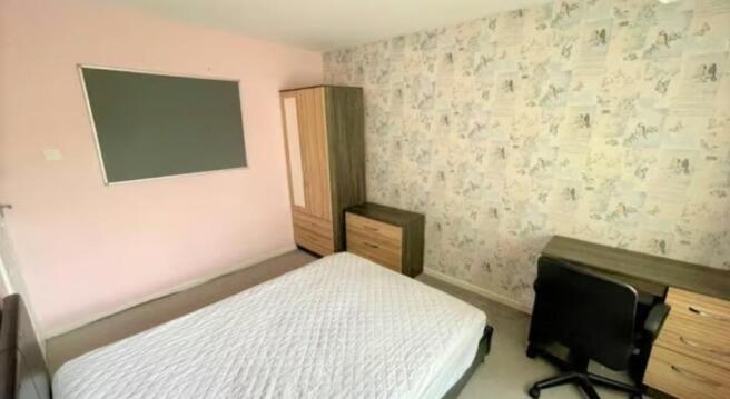 Bright and tidy master bedroom featuring a comf...