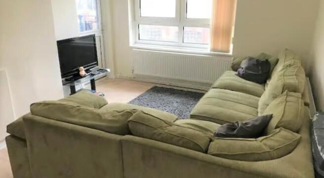 A cozy living room featuring a large comfortabl...