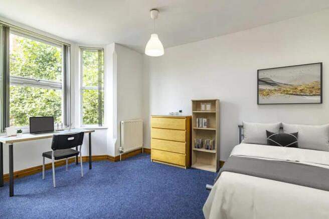 Bright and spacious master bedroom featuring la...