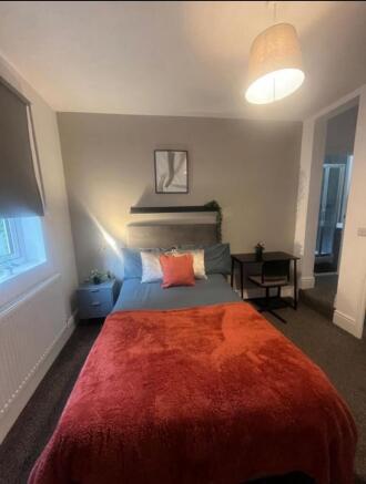 A cozy double bedroom featuring a comfortable b...
