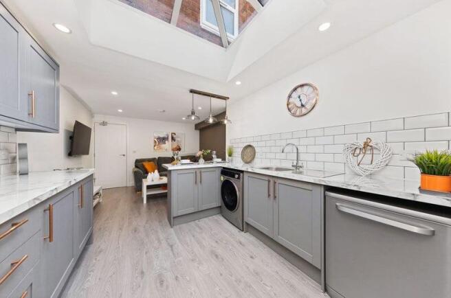 Bright and modern kitchen featuring stylish gre...