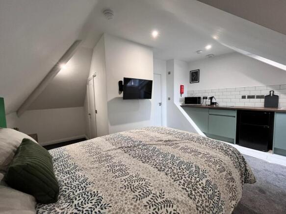 This charming double bedroom features a cozy am...