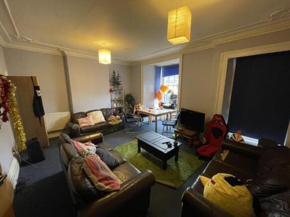 A spacious living room featuring comfortable le...