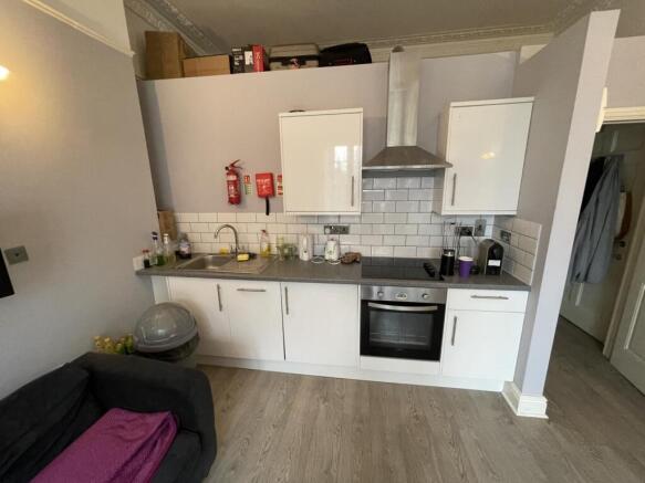 Modern kitchen area with white cabinetry, a sta...