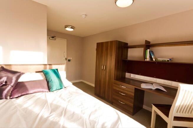 Bright and tidy double bedroom featuring a comf...