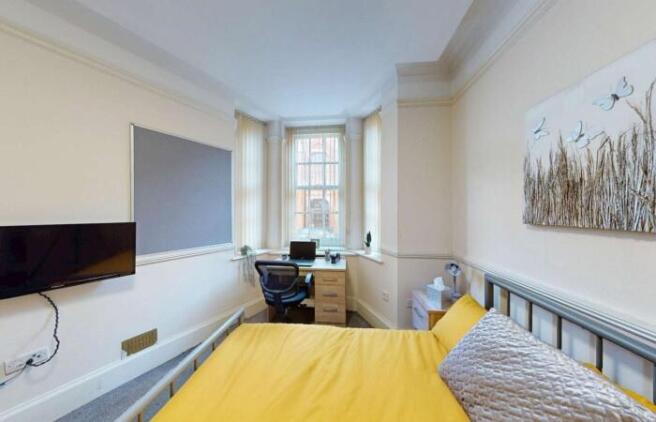 Bright and tidy double bedroom featuring a comf...