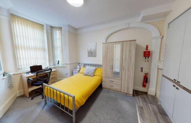 A bright and tidy single bedroom featuring a co...